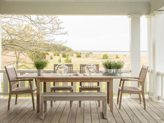 Teak table and chairs on a deck overlooking the ocean and marsh